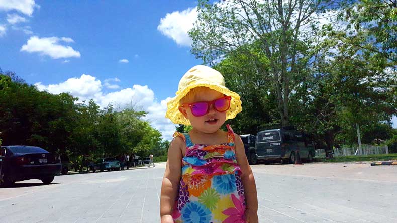 A blonde toddler wearing sunglasses and a sunhat in Guatemala
