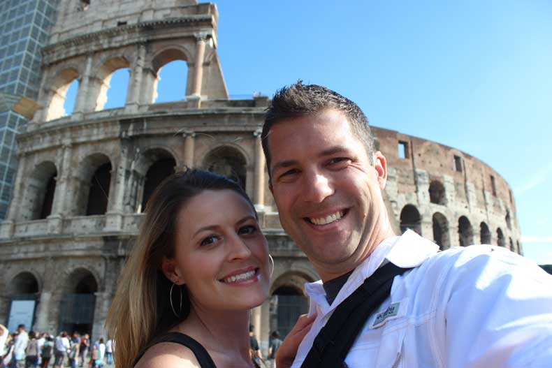  traveling as a couple in front of the Colosseum in Rome