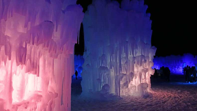Ice Castles lit up in pink and blue at night