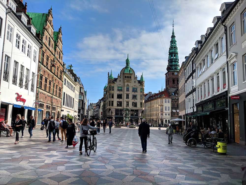 People walking and cycling along Stroget, an entertainment and shopping street in central Copenhagen and one of the best things to do with kids in Copenhagen