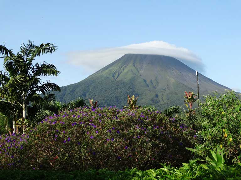 One of the best places to visit in Central America - the Arenal Volcano shrouded in clouds is a top destination in Costa Rica with kids 