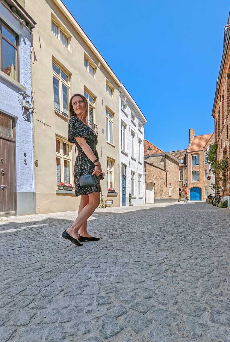 Woman walking down a quiet side street in Bruges.