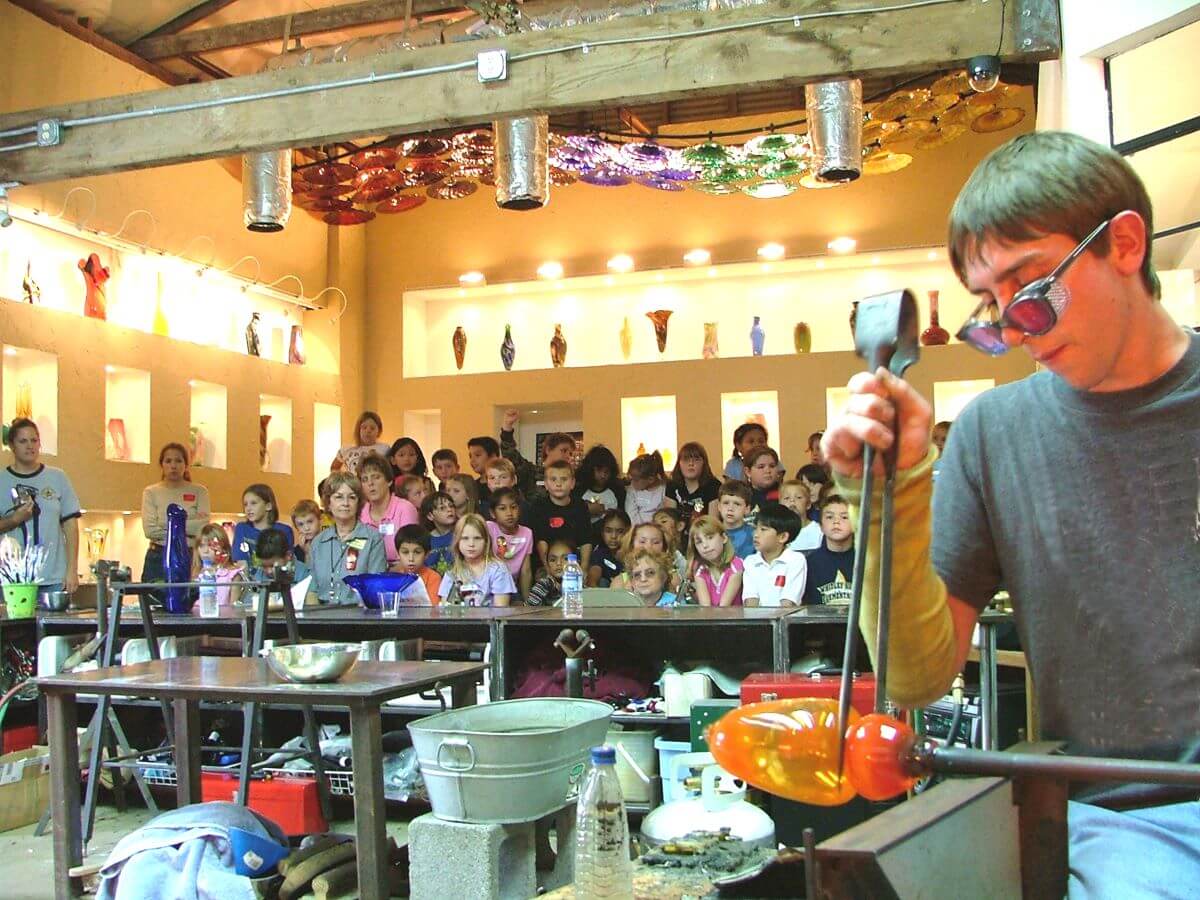 a glass artist golding a demonstration at Vetro Glassblowing Studio in Grapevine
