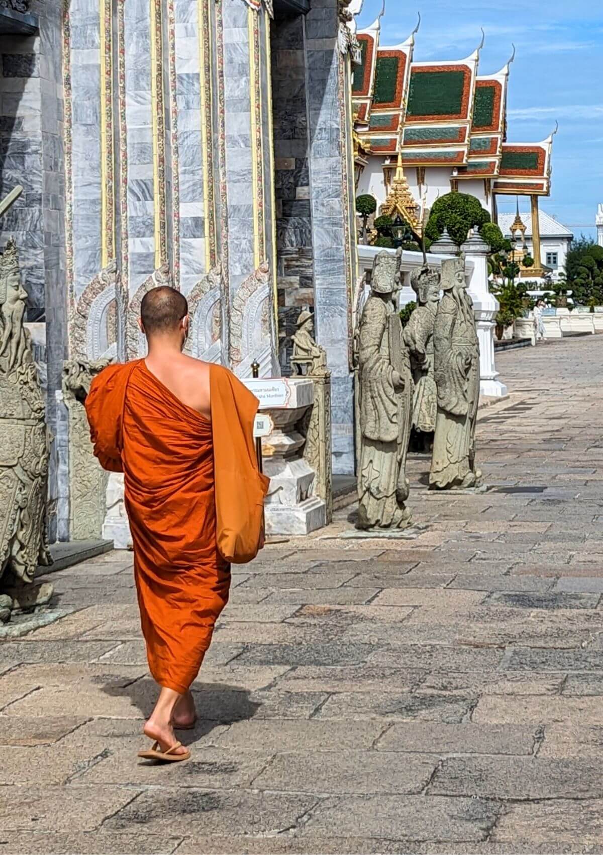 a monk walking by a temple in thailand