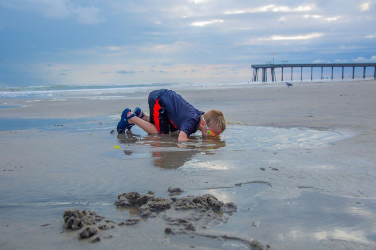 a little boy playing in the sand at a beach along the Jersey Shore