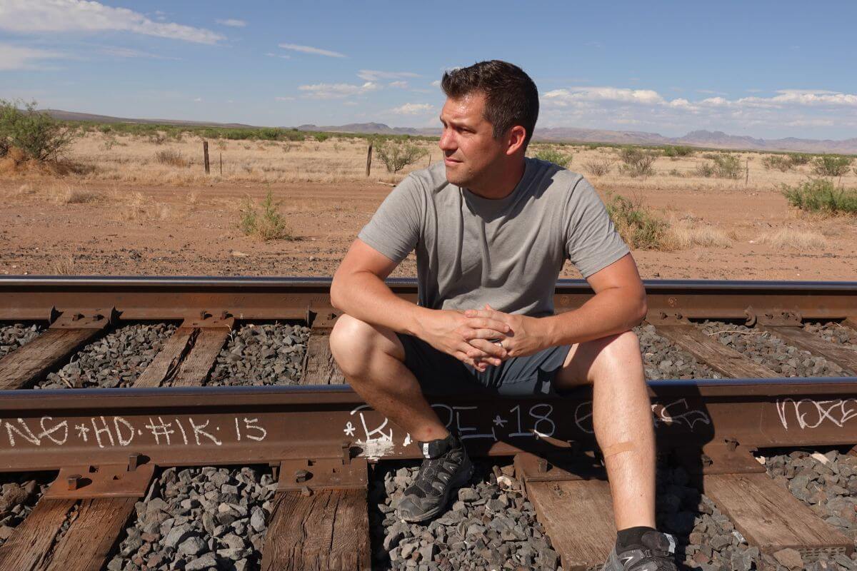 my husband sitting on railroad tracks in west texas