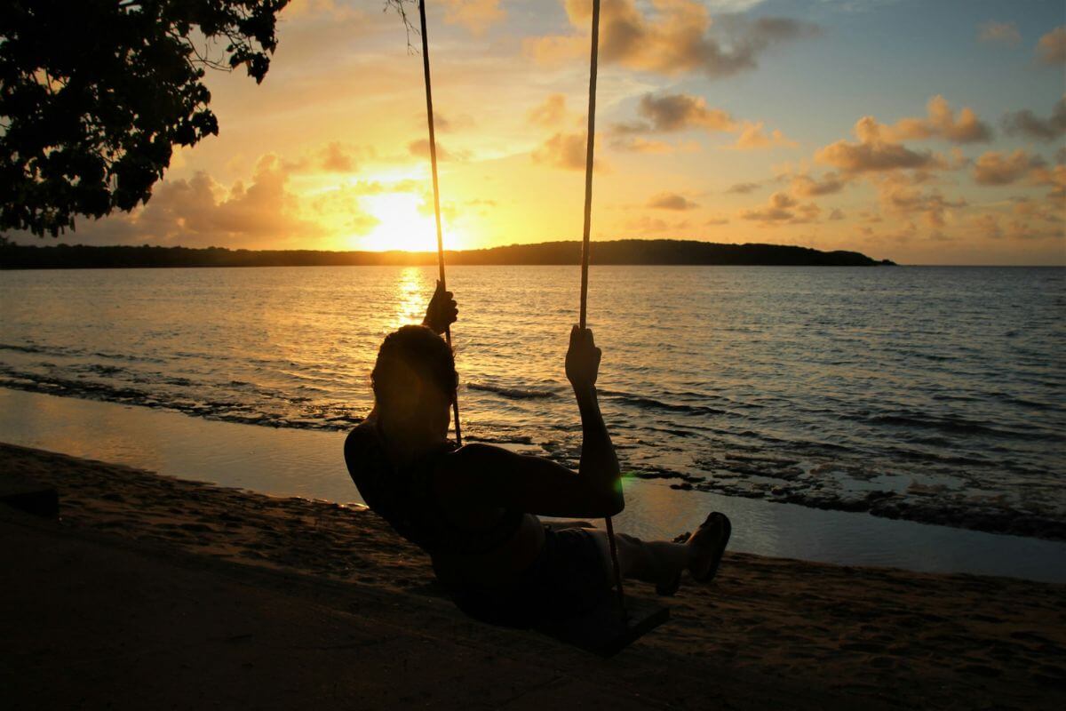 person on a beach swing at sunset in fajardo